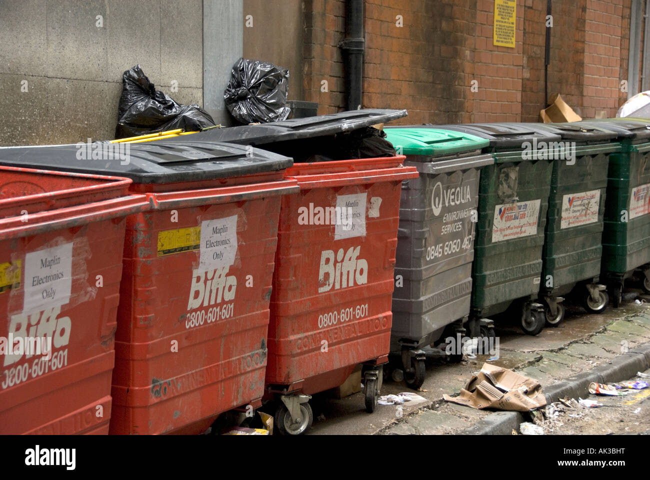 rubbish containers in a street in birmingham used as commercial bins Stock Photo