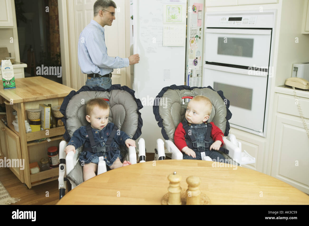 Twin babies in high chairs Stock Photo Alamy