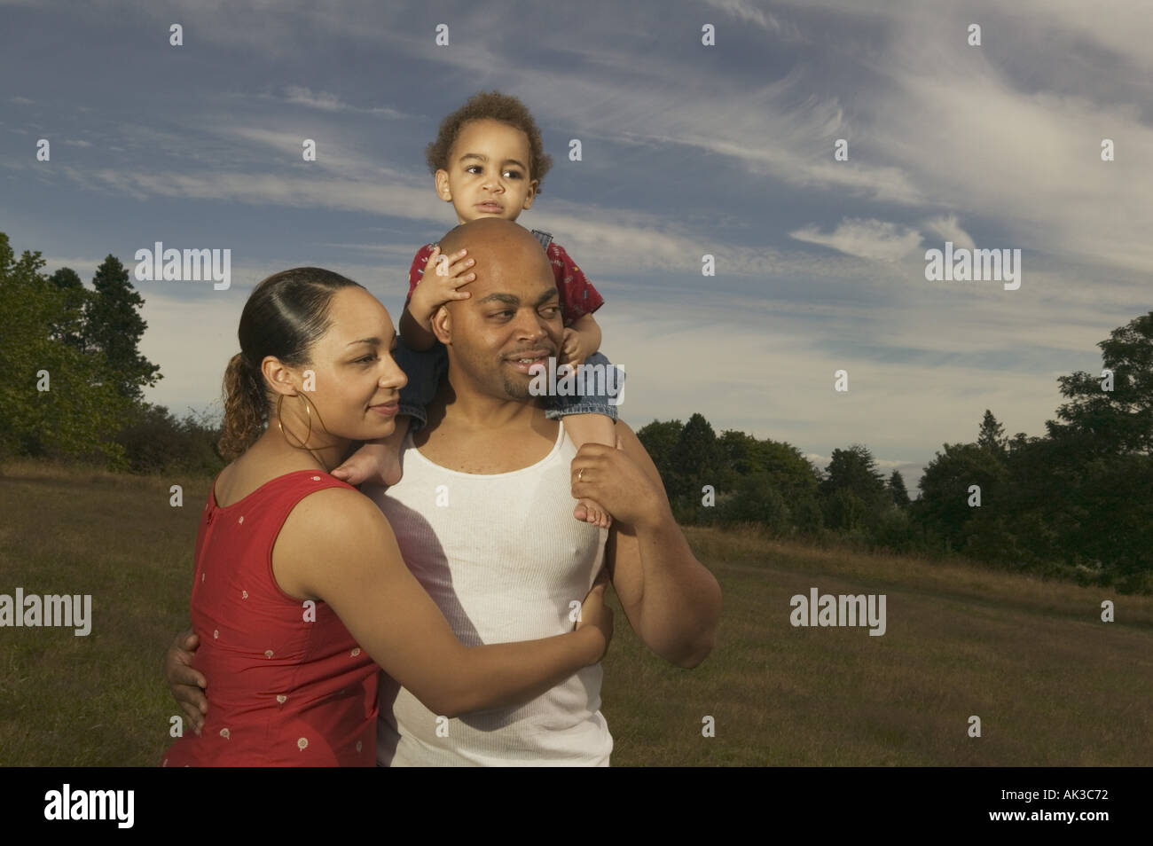 A family hugging in a green meadow Stock Photo