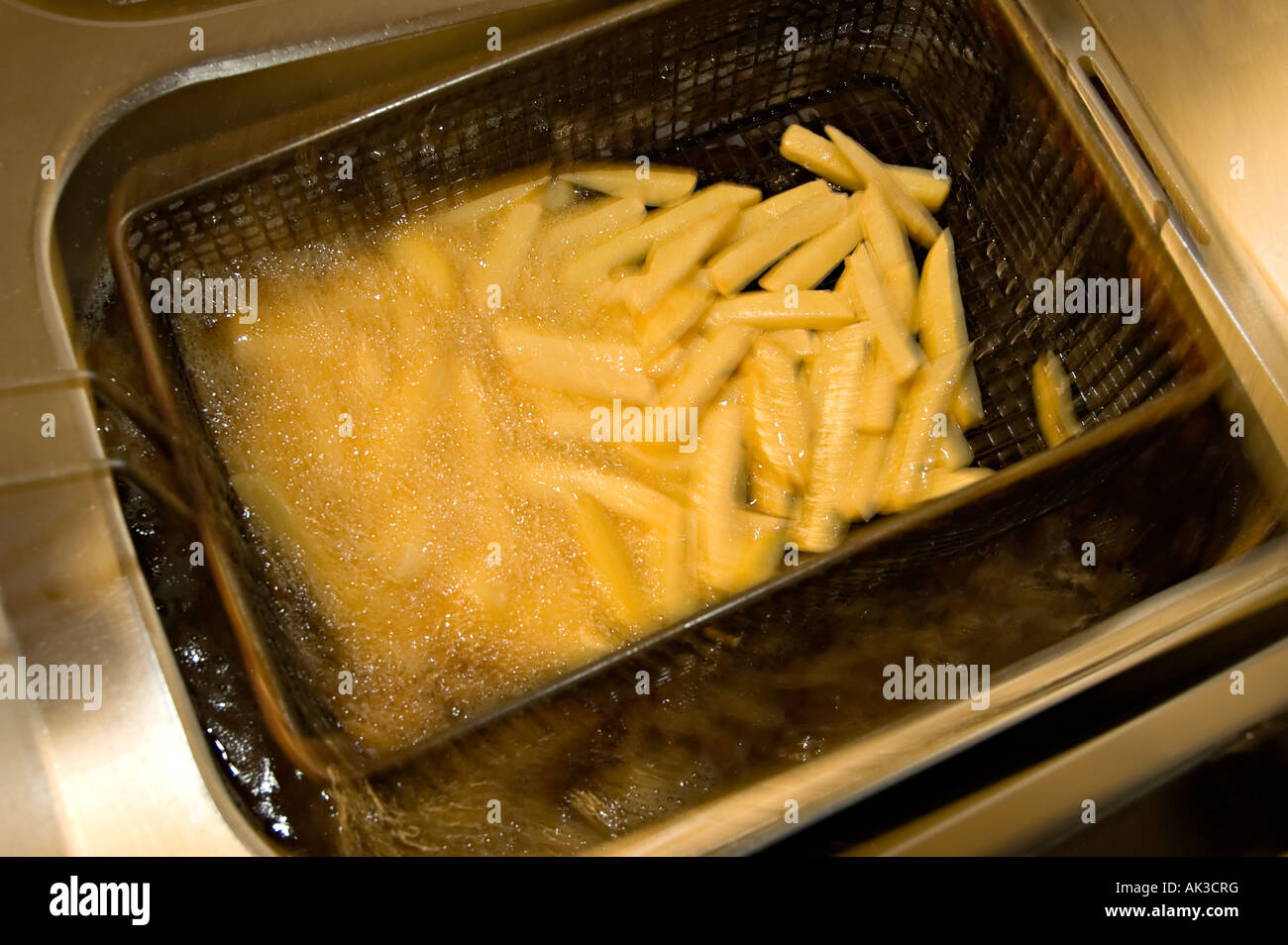 deep fried chips being deep fried for eating Stock Photo