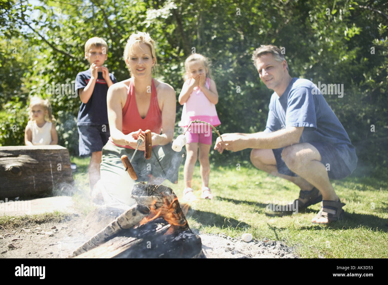 Family gathered around the campfire Stock Photo
