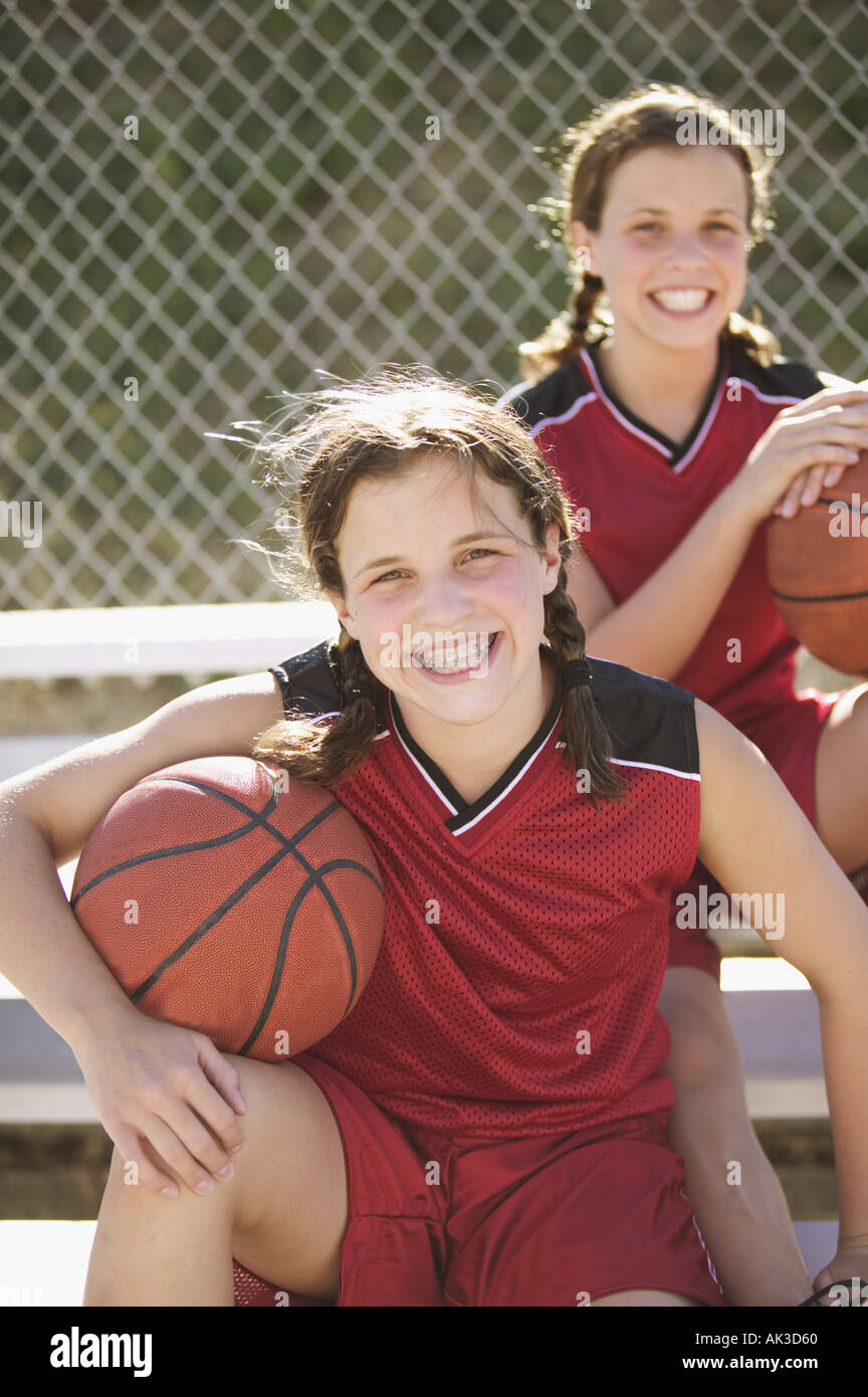Twin teen girls holding basketballs Stock Photo