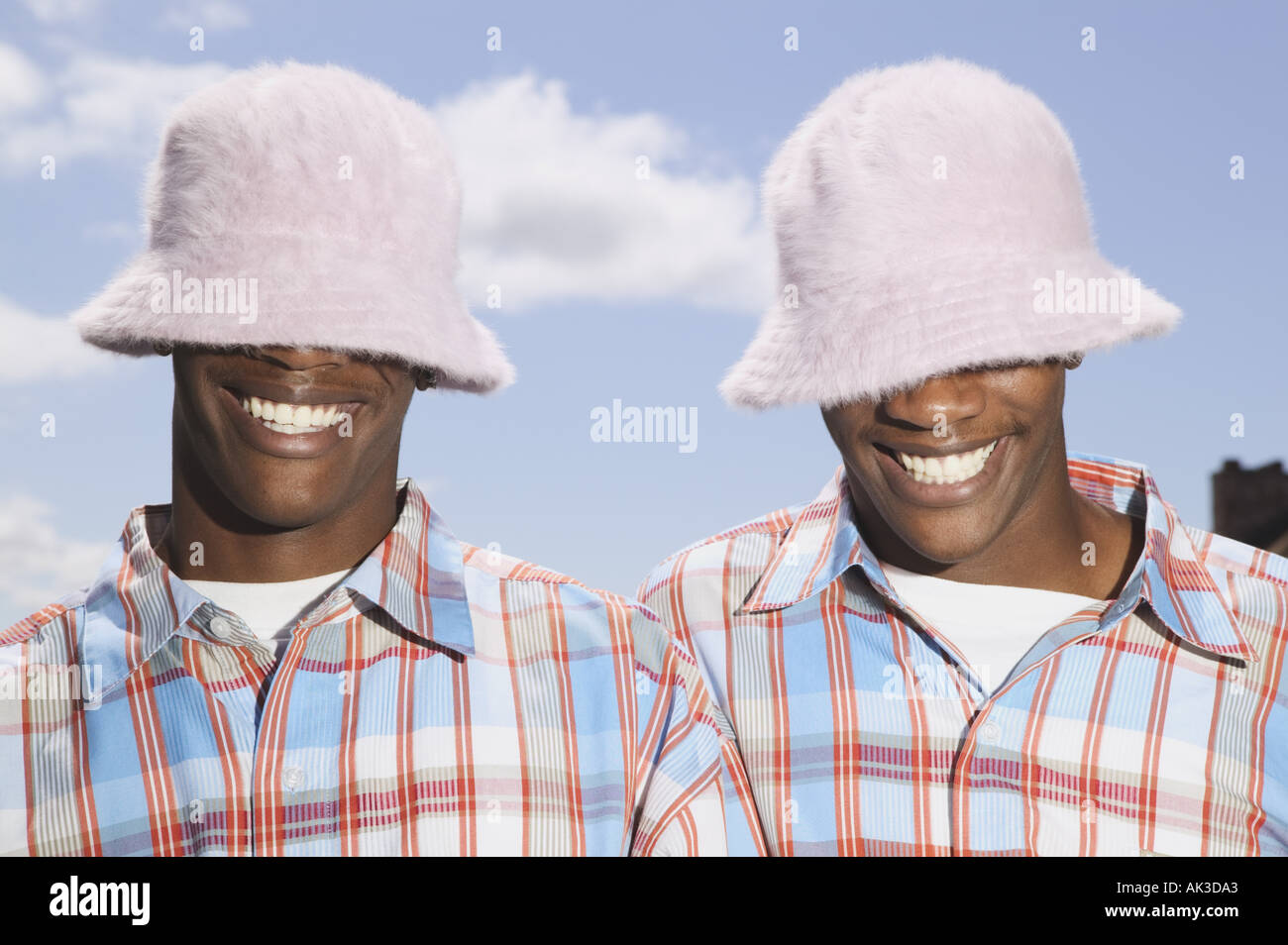 Twin teenage boys in matching hats and shirts Stock Photo