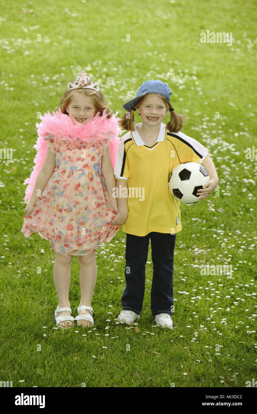 Twin girls dressed in contrasting styles Stock Photo