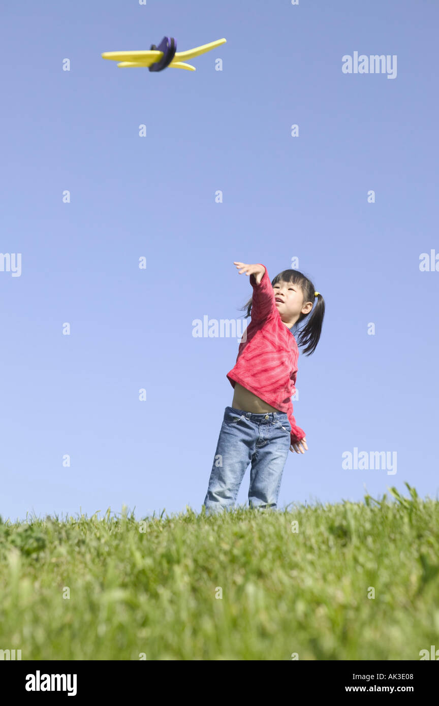 Young girl playing with a toy airplane Stock Photo