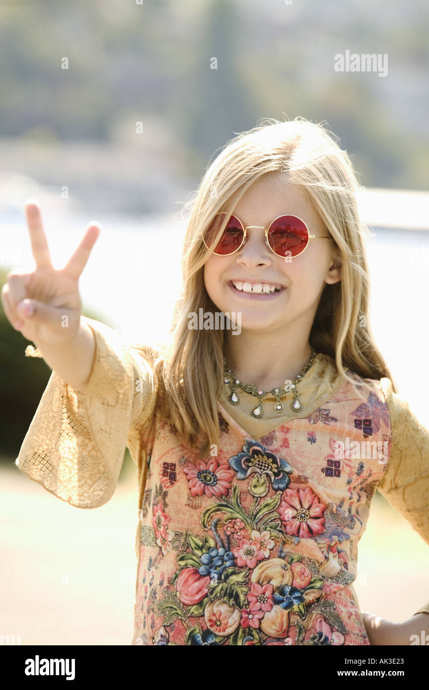 young girl in sunglasses making a peace sign AK3E23