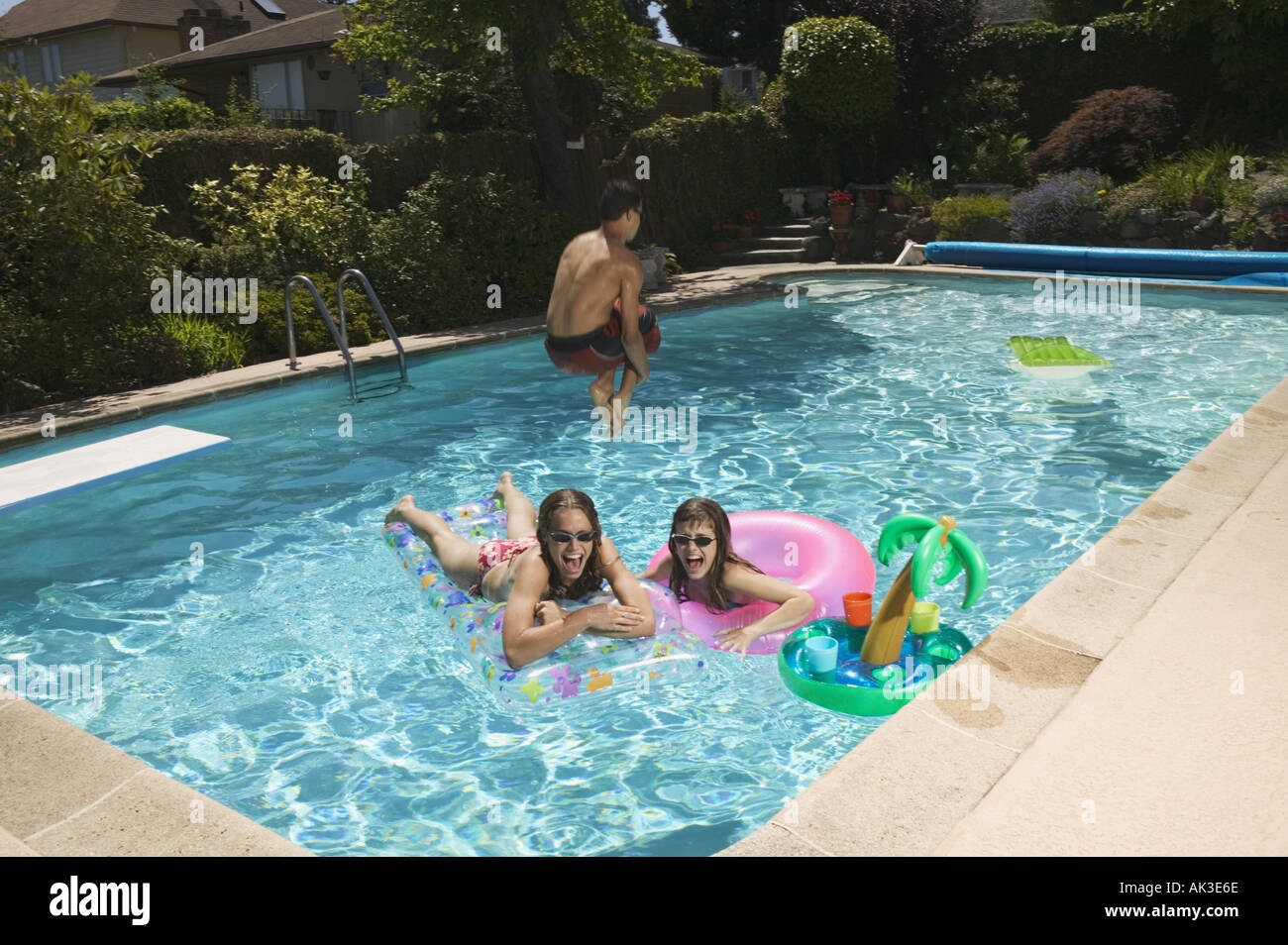 Teenagers playing in a swimming pool Stock Photo