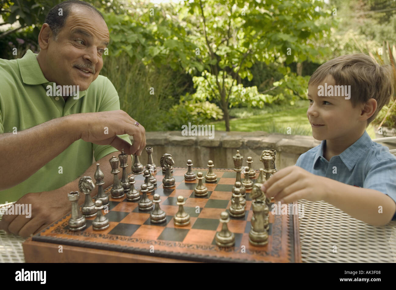 Senior man playing chess with his young grandson Stock Photo
