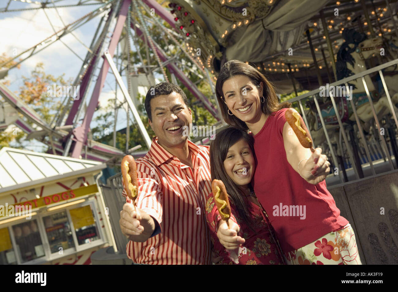Parents and daughter eating at an amusement park Stock Photo