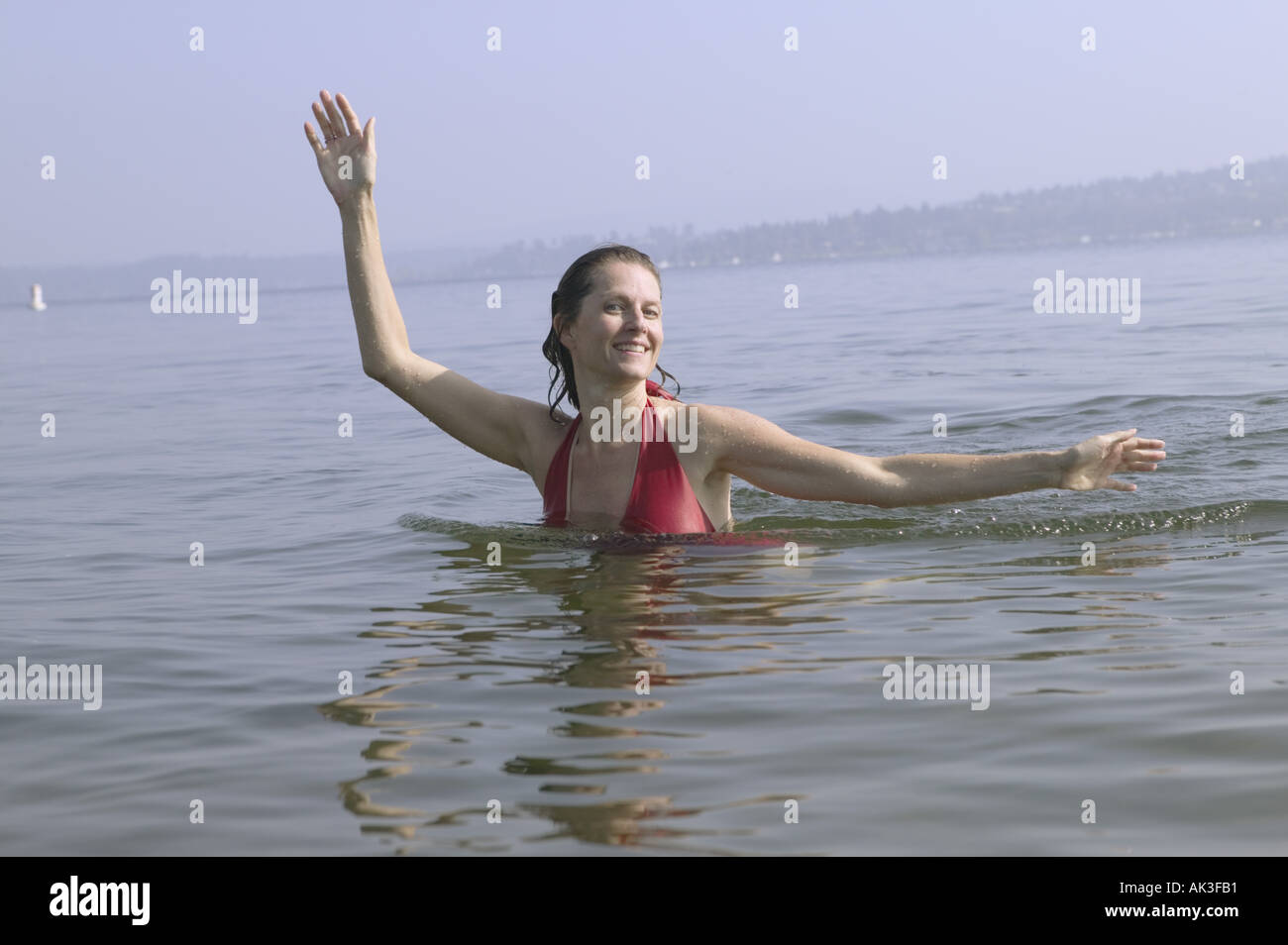 A woman swimming and posing in a lake Stock Photo