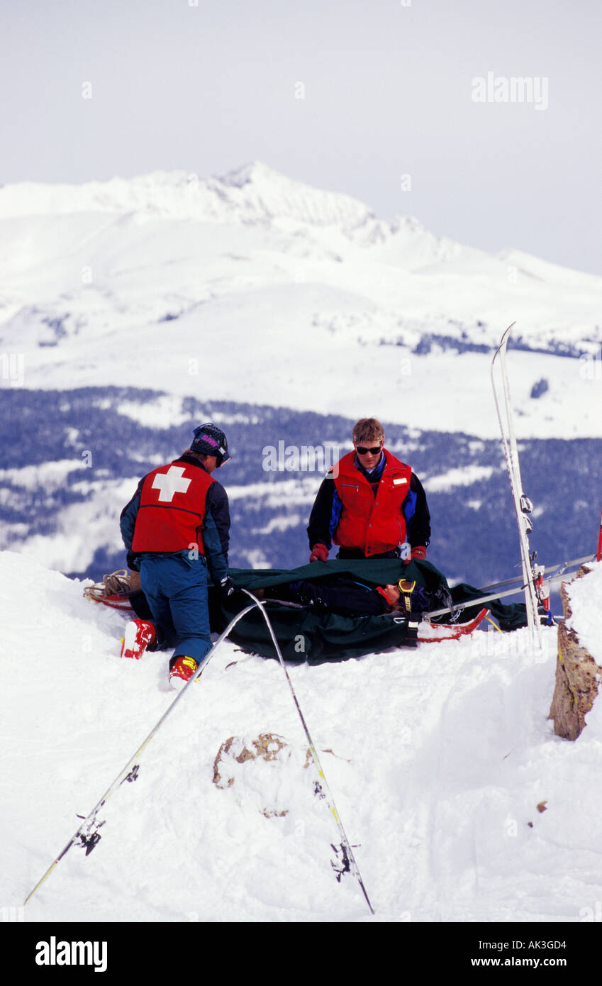 The ski patrol attends to an injured female skier in the Colorado