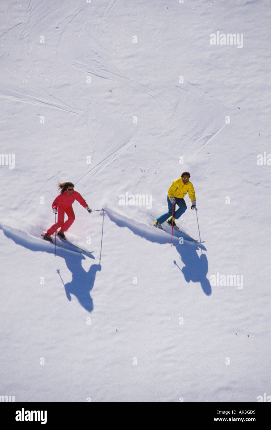 A couple ski an extremely steep slope in perfect unison Stock Photo