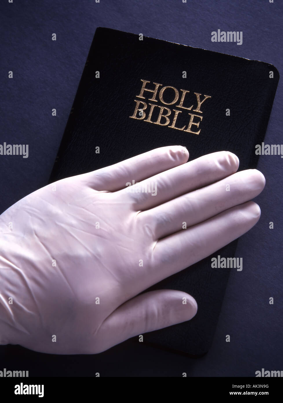 gloved doctors hand on bible Stock Photo