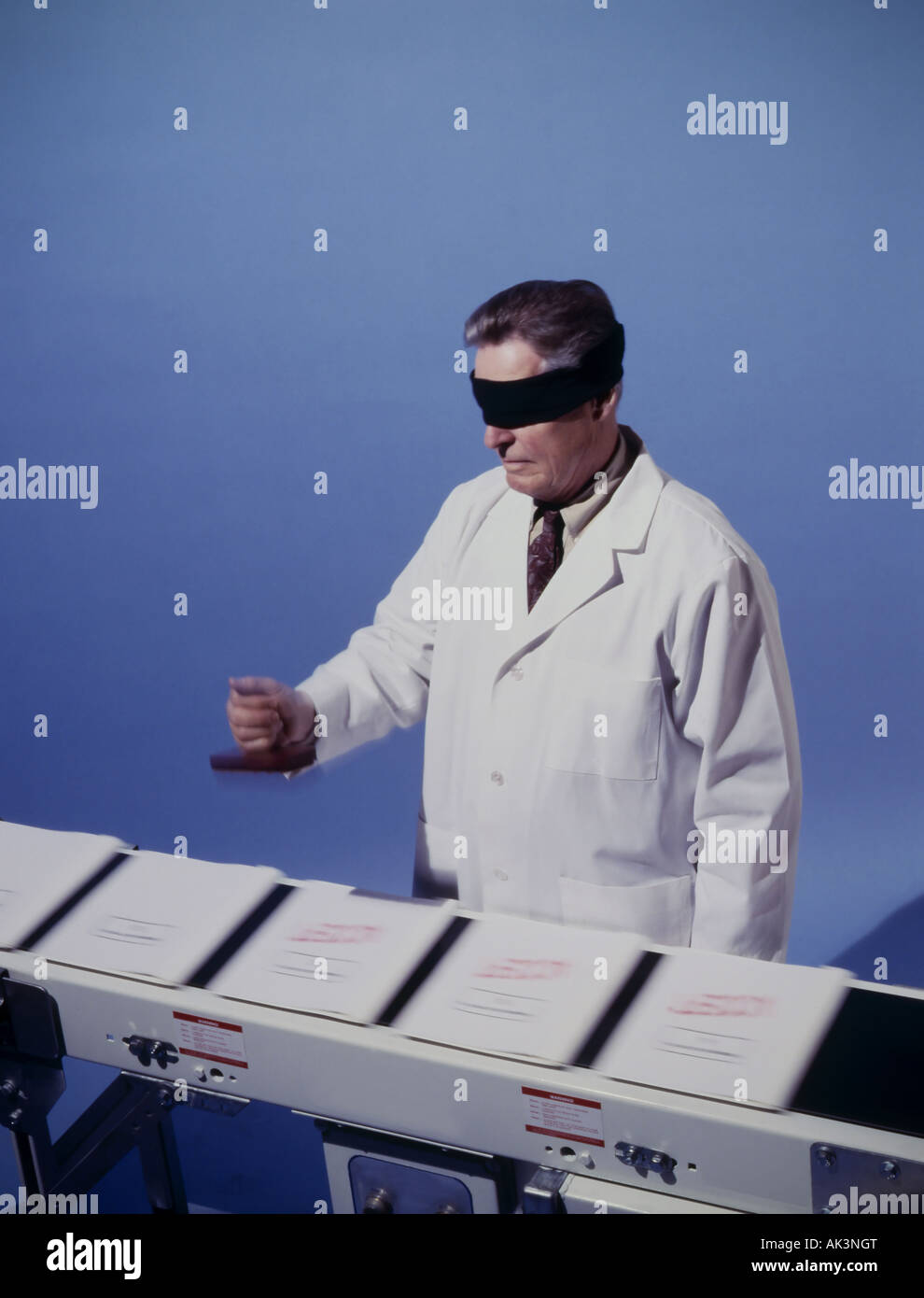 blind folded Doctor stamping forms on a conveyor belt Stock Photo