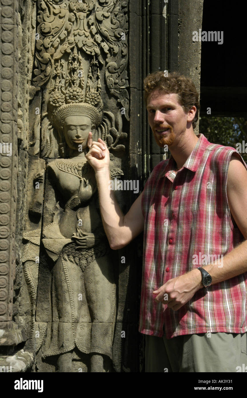 MR tourist is standing beside a stone relief of fine arts showing a charming Stock Photo