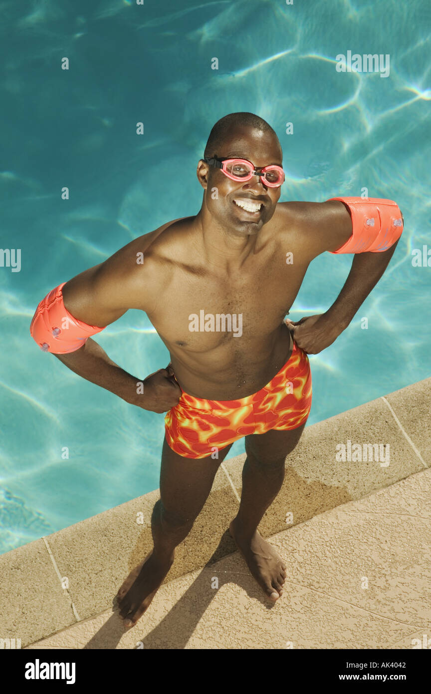 A man with his hands on hips at poolside Stock Photo