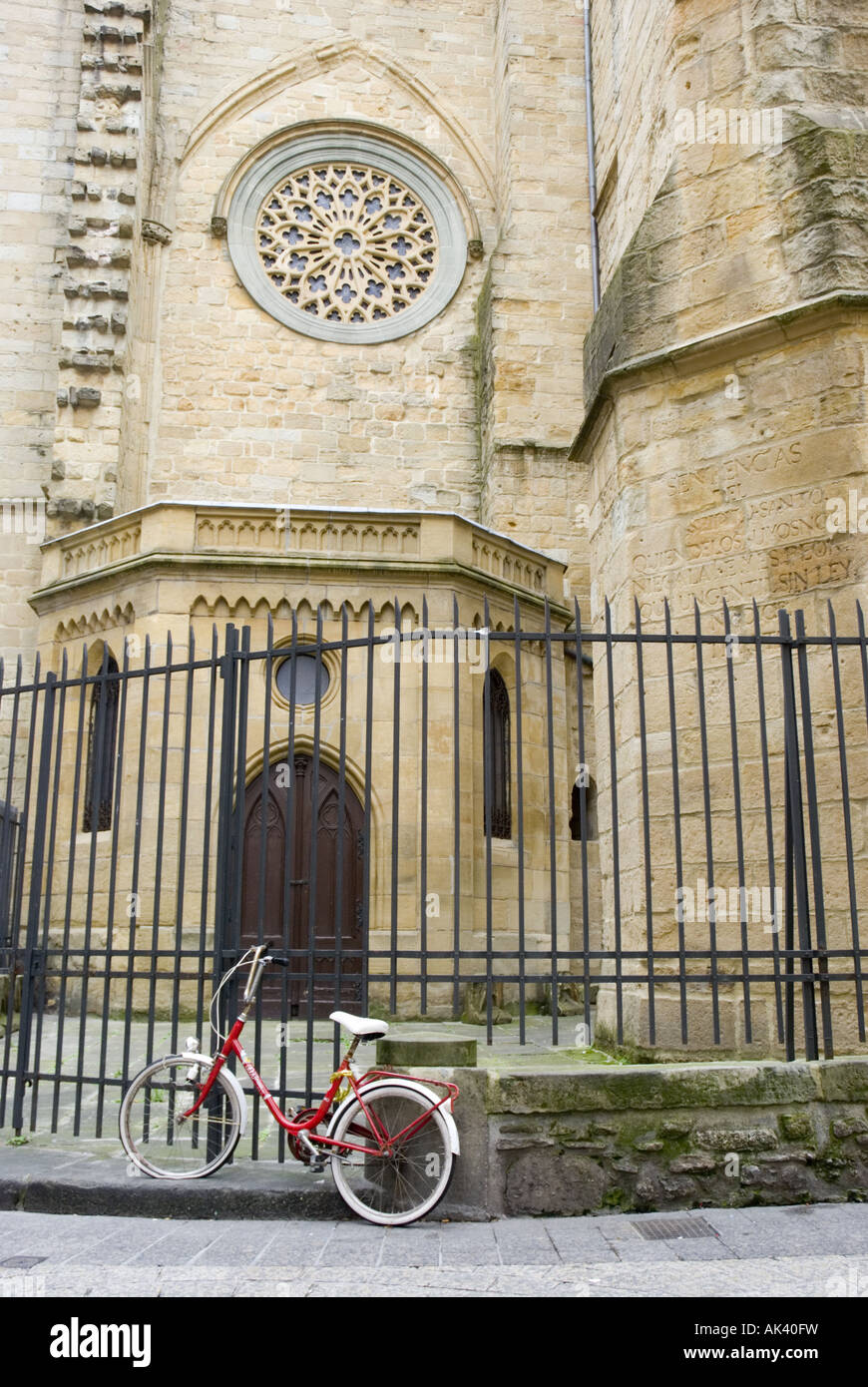A bicycle is chained to a iron railings outside a church in San Sebastian's Old Town, Spain. Stock Photo