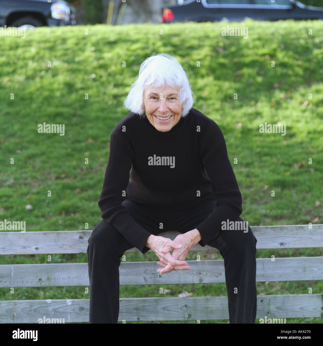 Portrait of a senior woman sitting on a park bench Stock Photo - Alamy