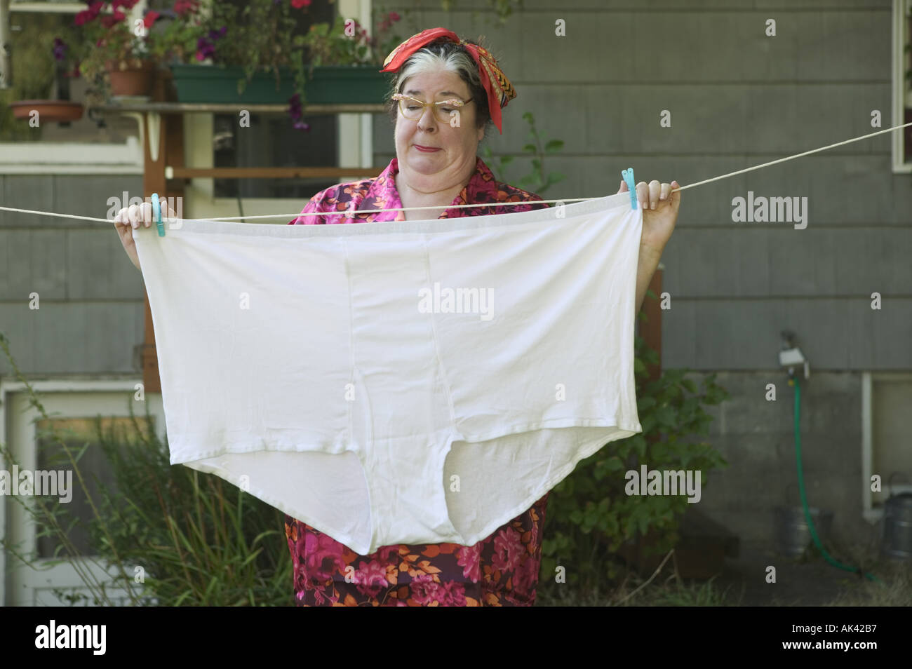 Woman behind a huge pair of underwear on a clothesline Stock Photo
