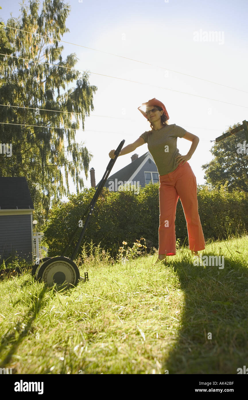 Caucasian woman mowing the lawn Stock Photo