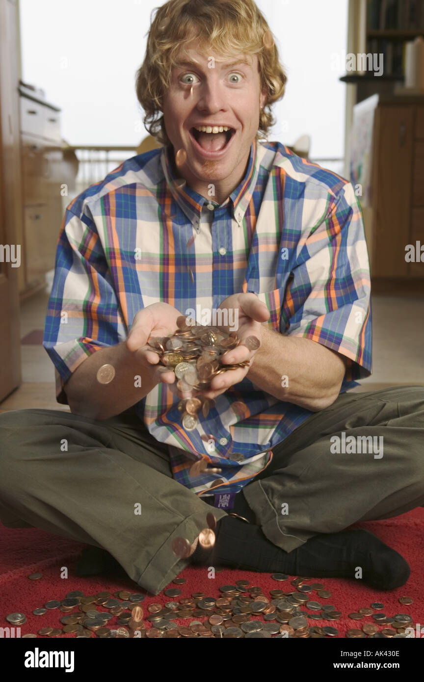Man tossing a pile of loose change Stock Photo