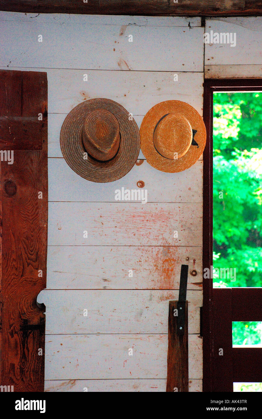 straw hats hanging on wooden cabin wall. Stock Photo