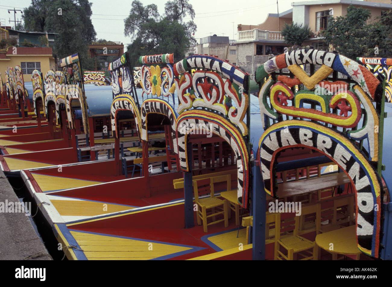 Colorful trajineras docked at an embarcadero in Xochimilco, Mexico City Stock Photo