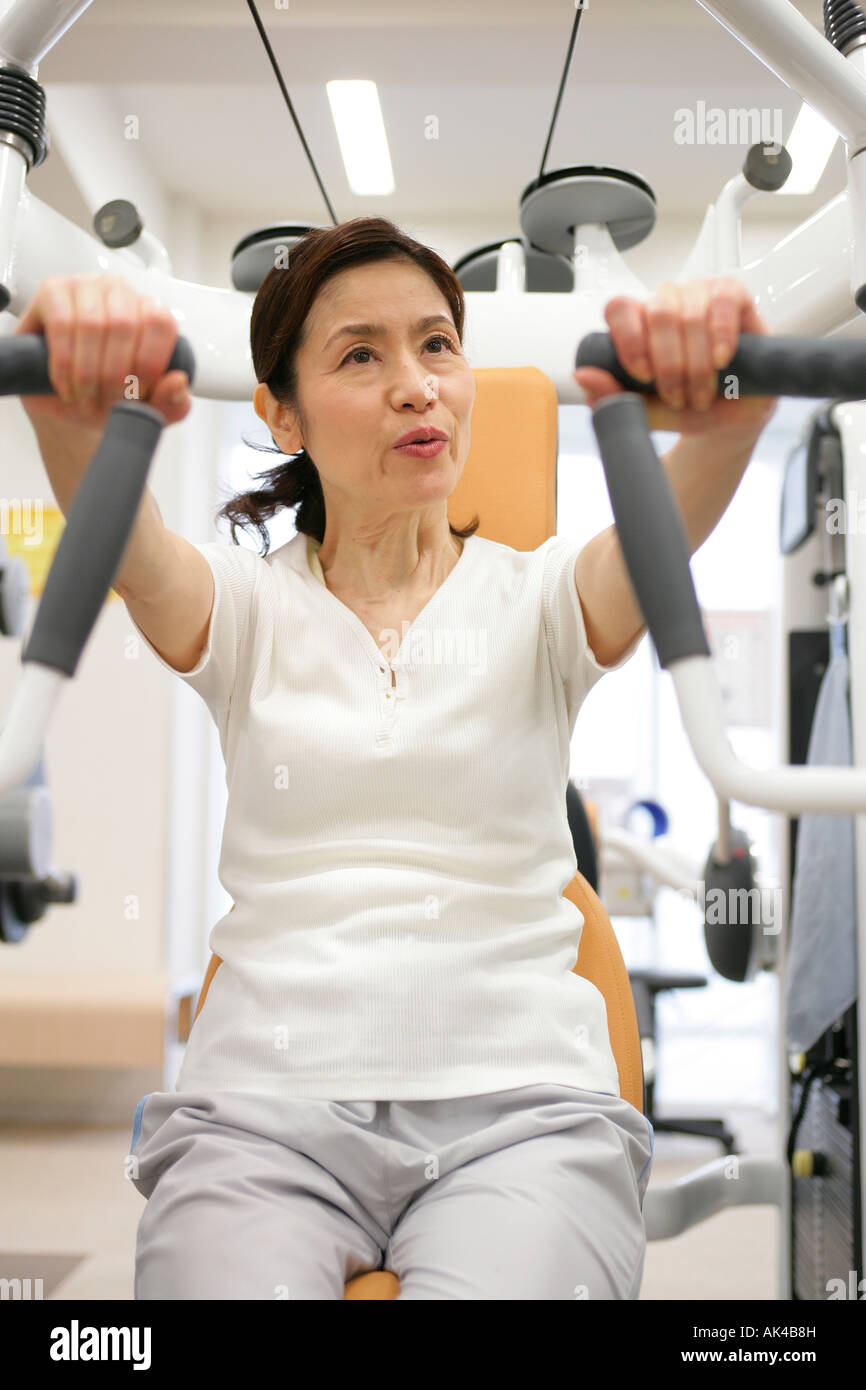 Mature woman on exercise machine in gym Stock Photo - Alamy