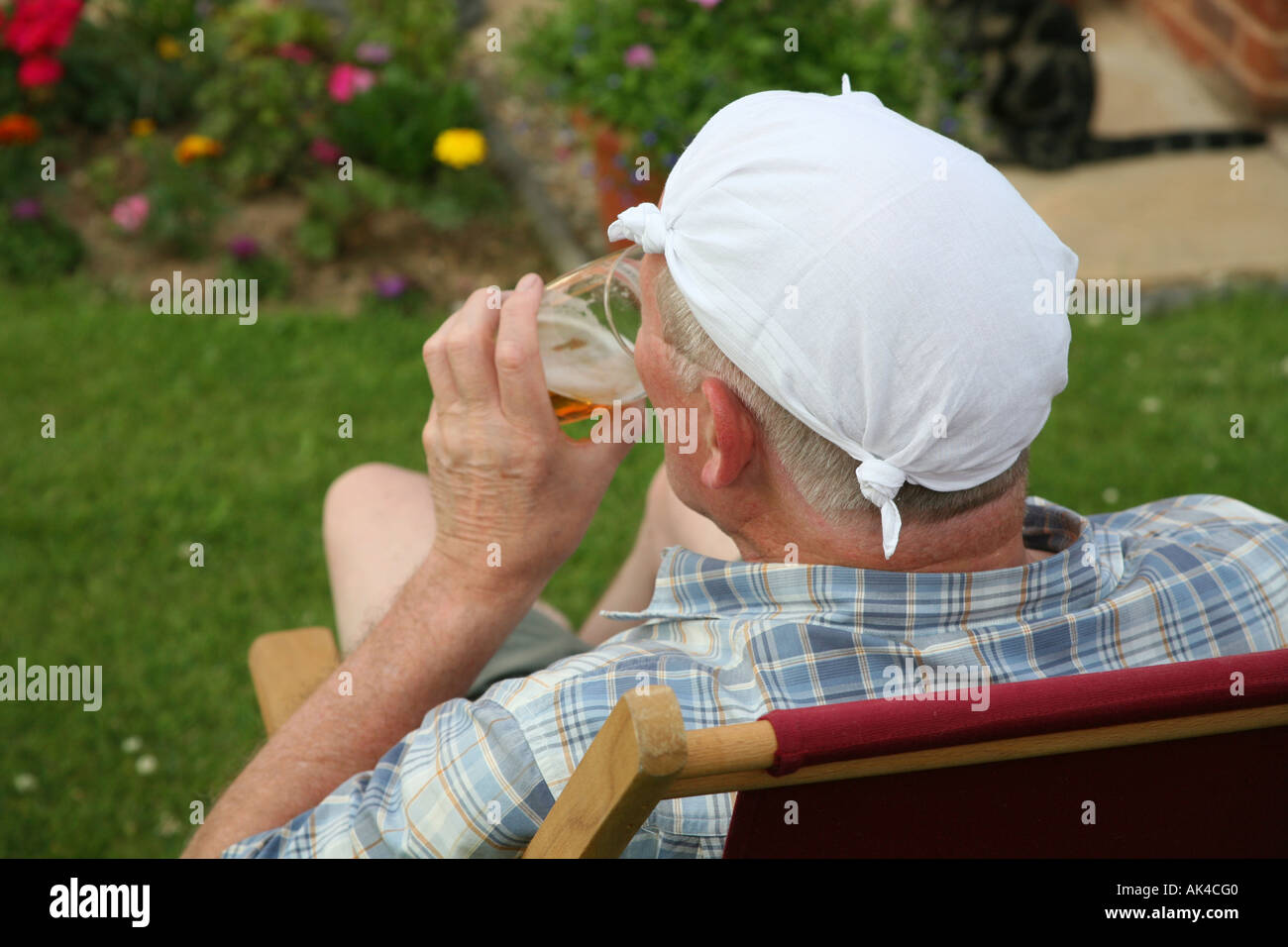 Man enjoying a beer in a garden on a summer evening Stock Photo