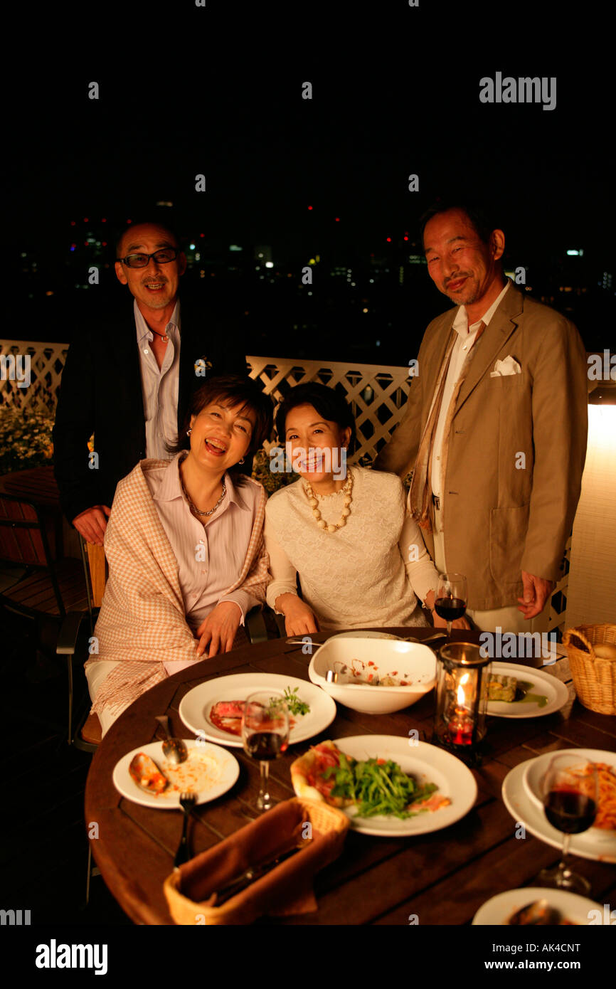 Four adults relaxing over dinner Stock Photo - Alamy