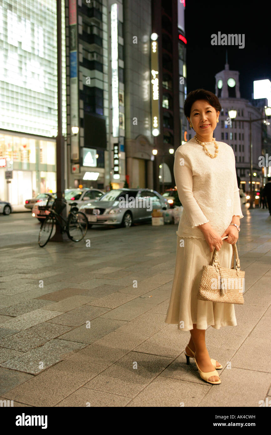 Mature woman standing on the street at night Stock Photo - Alamy