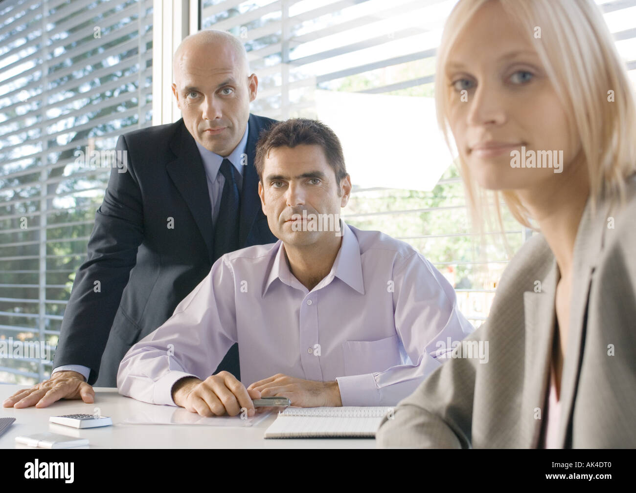 Three business executives in office, looking at camera Stock Photo