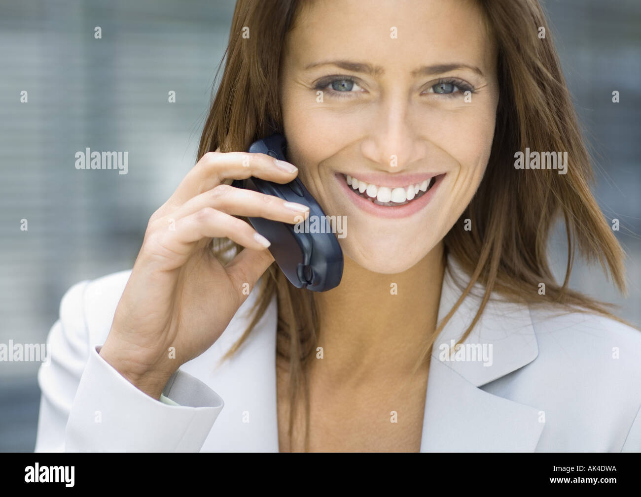 Businesswoman using cell phone, smiling Stock Photo
