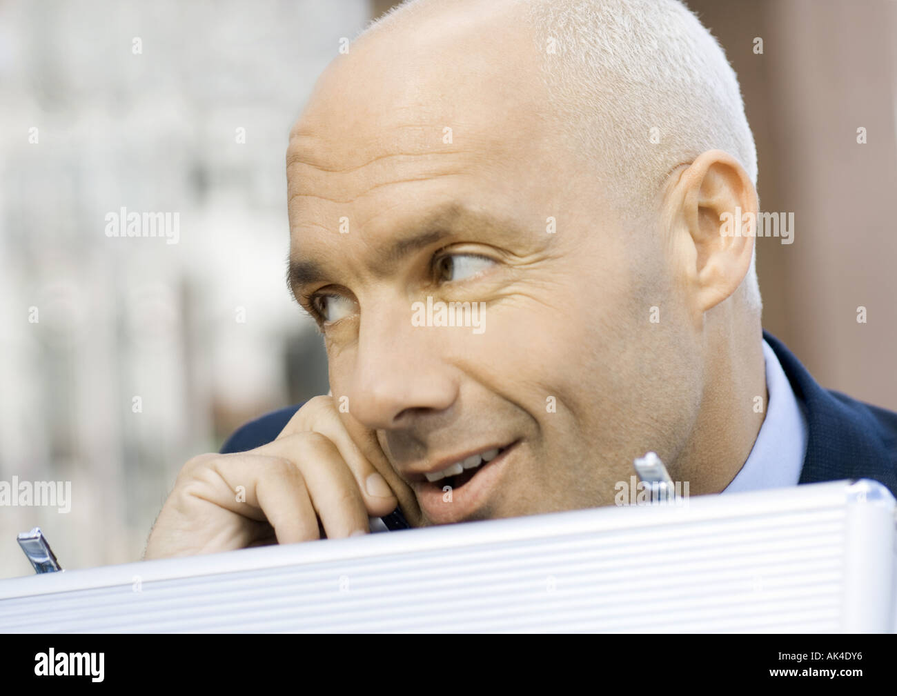 Businessman using cell phone and opening briefcase Stock Photo