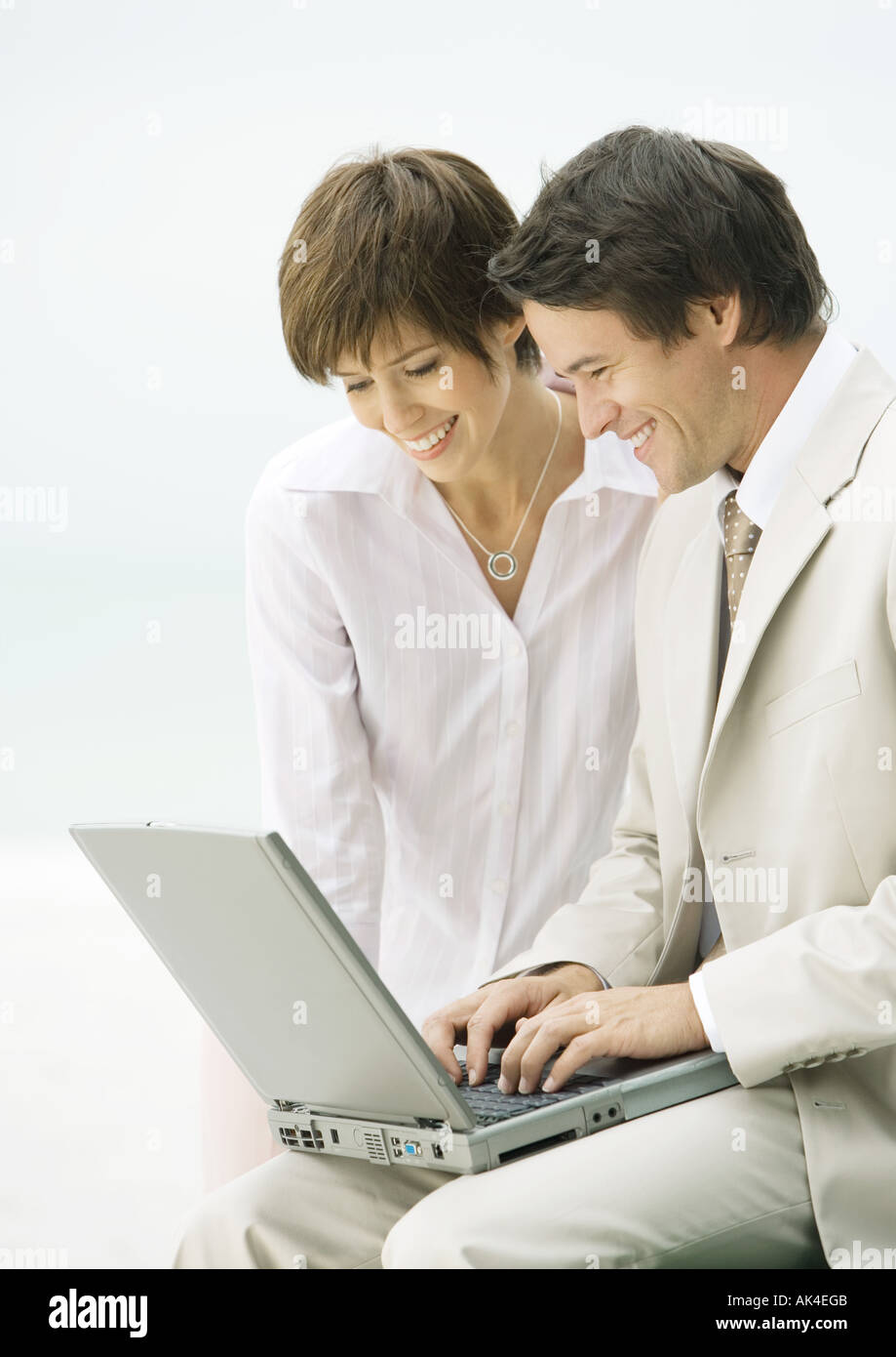 Businessman and woman using laptop together Stock Photo