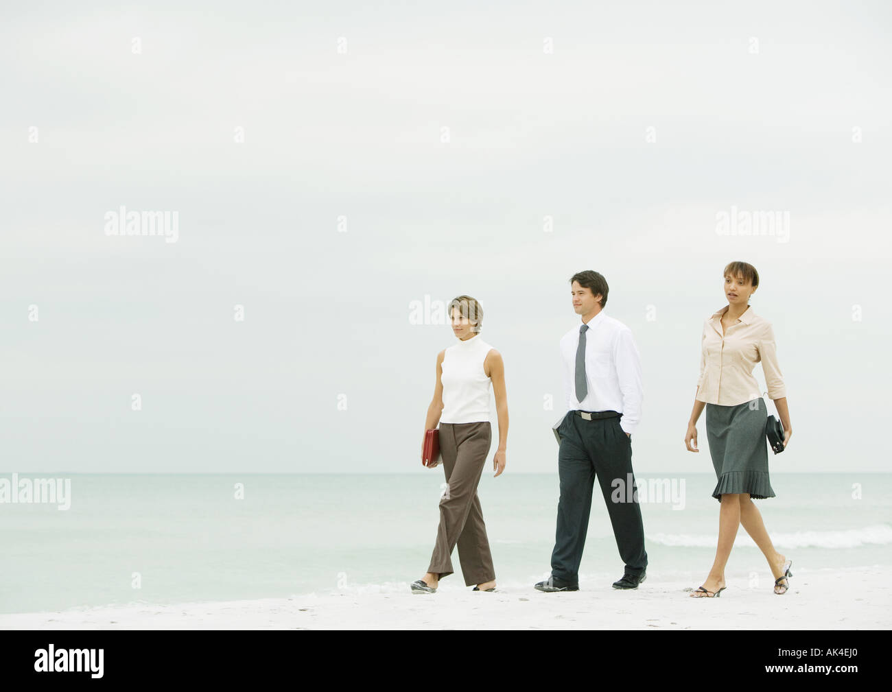 Business team walking on beach Stock Photo