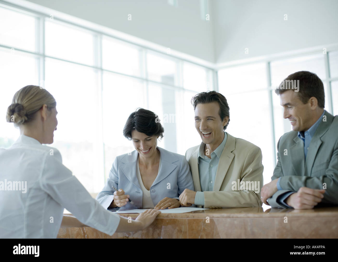People standing at reception desk, laughing Stock Photo Alamy