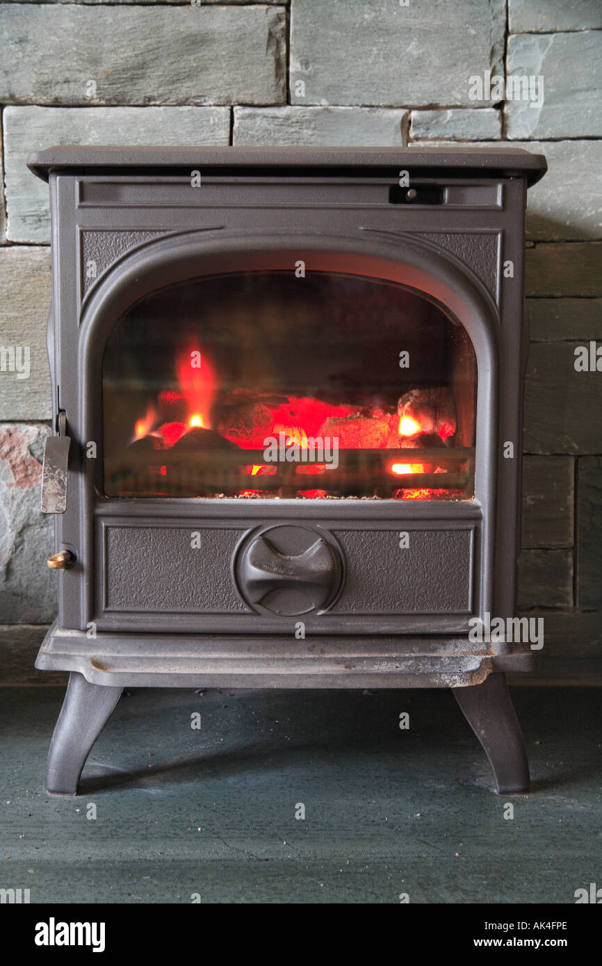 'Wood burning stove' standing on a Slate hearth with a slate surround, traditional. Stock Photo
