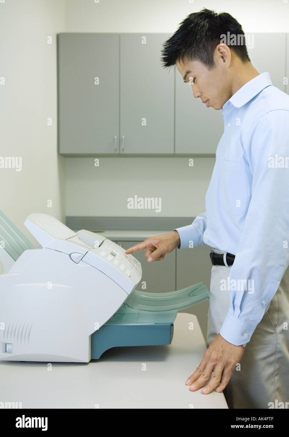 Male office worker using fax machine Stock Photo - Alamy