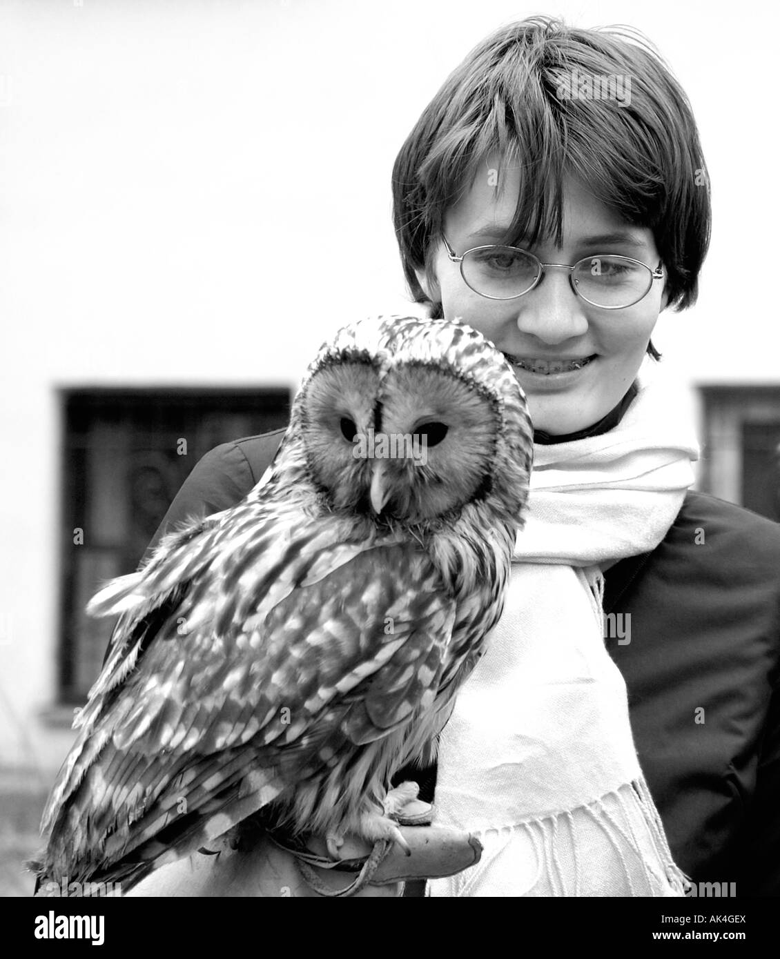Girl wearing glasses holds a twany owl Strix aluco Stock Photo
