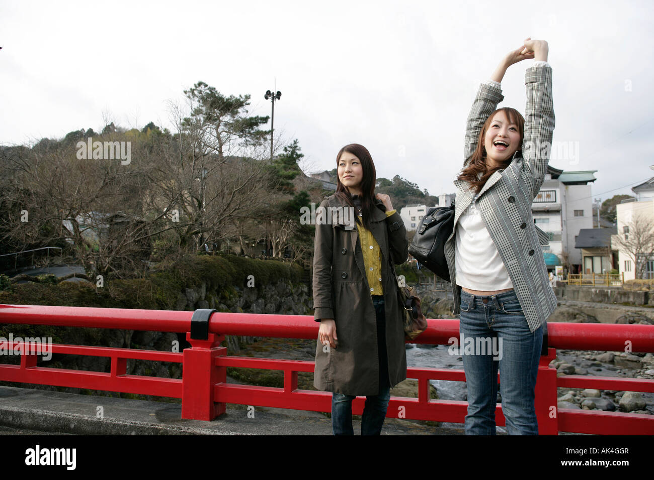 Two young women standing by the bridge Stock Photo - Alamy