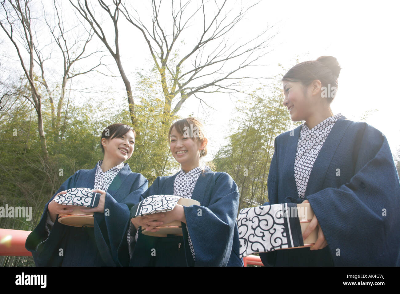 Three women with buckets, walking on bridge Stock Photo Alamy