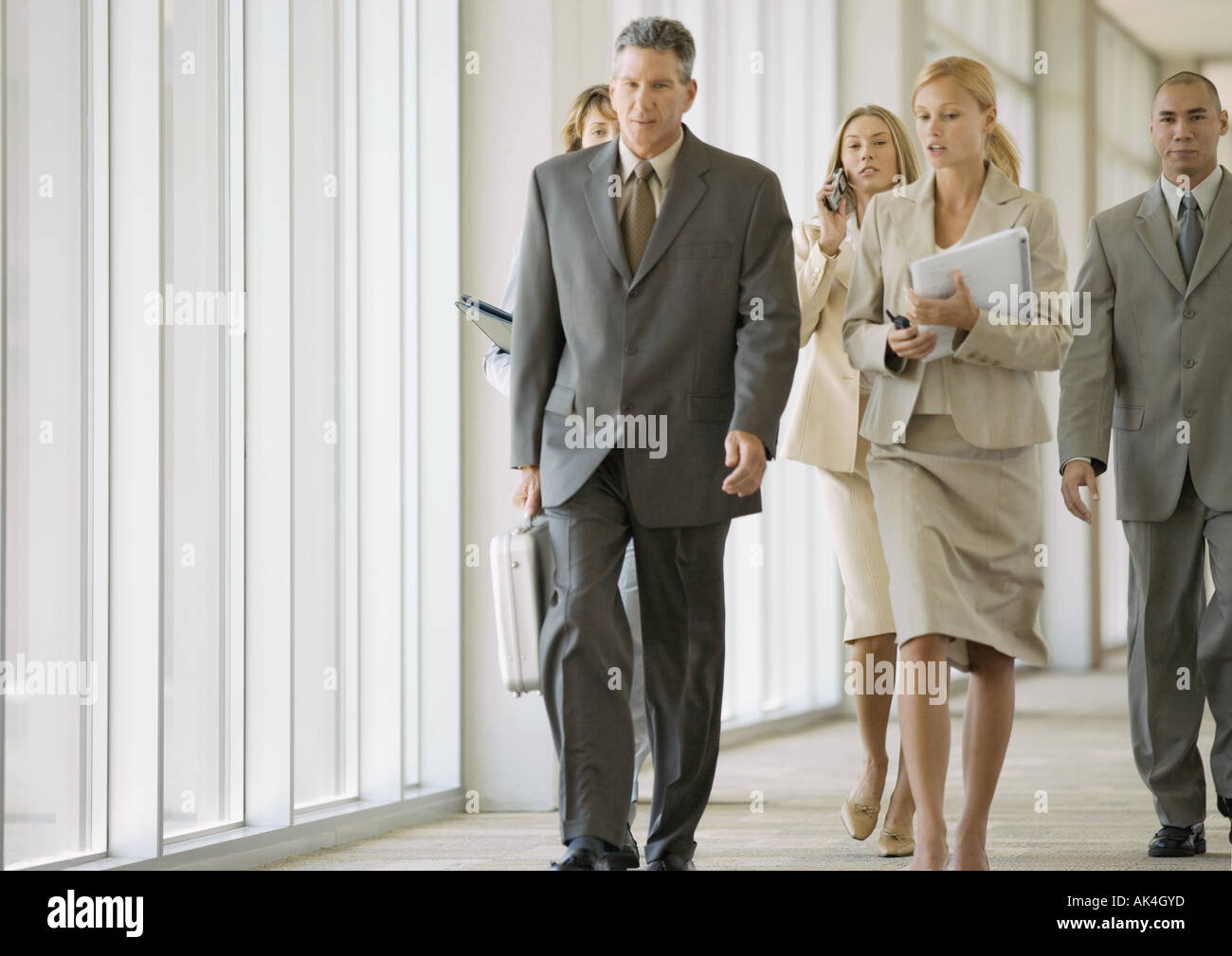 Executives walking through corridor of office building Stock Photo