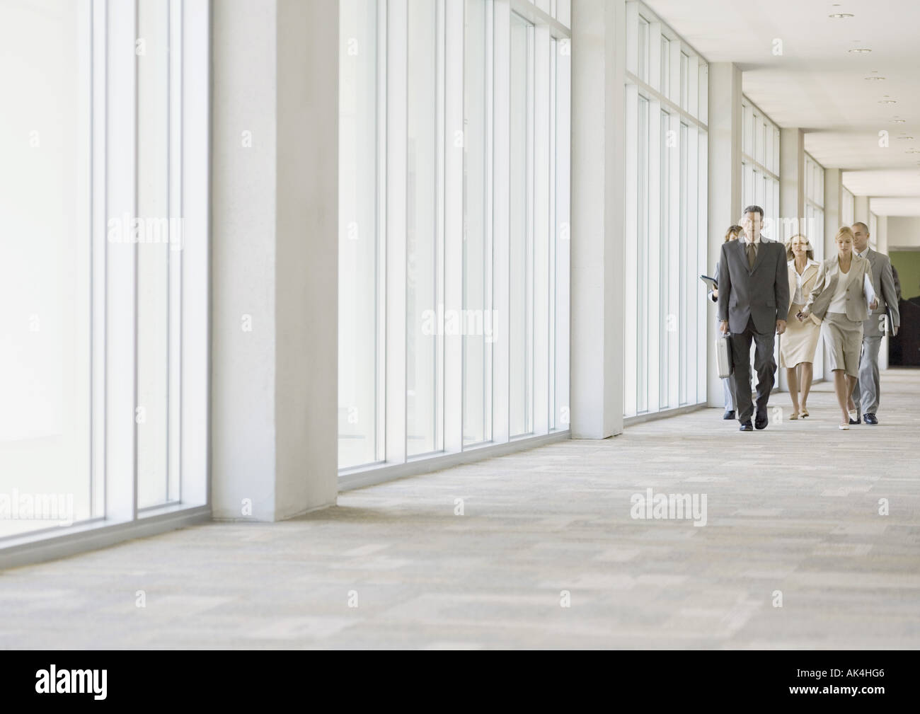 Executives walking through corridor of office building Stock Photo