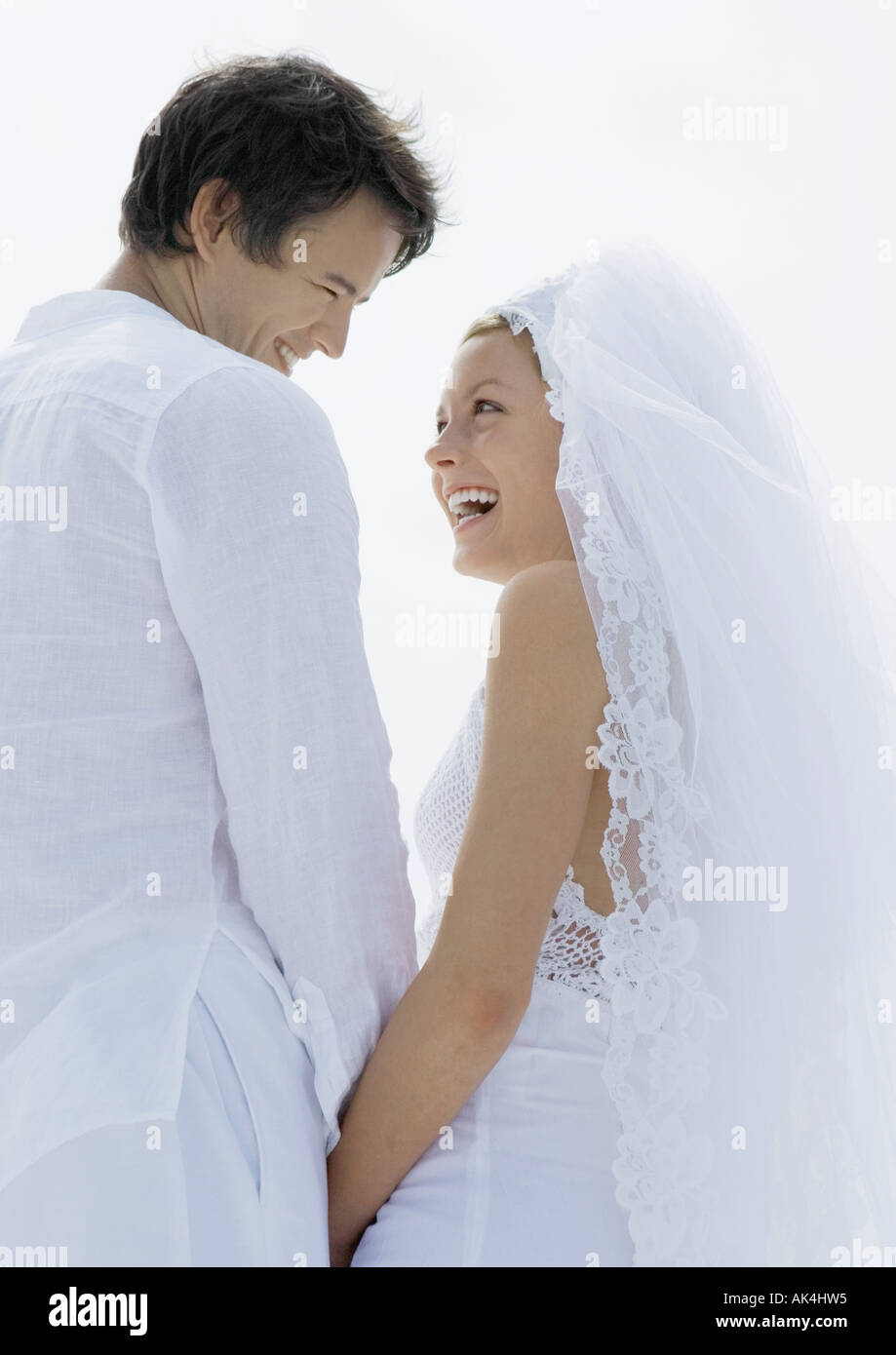 Bride and groom smiling at each other, low angle view Stock Photo