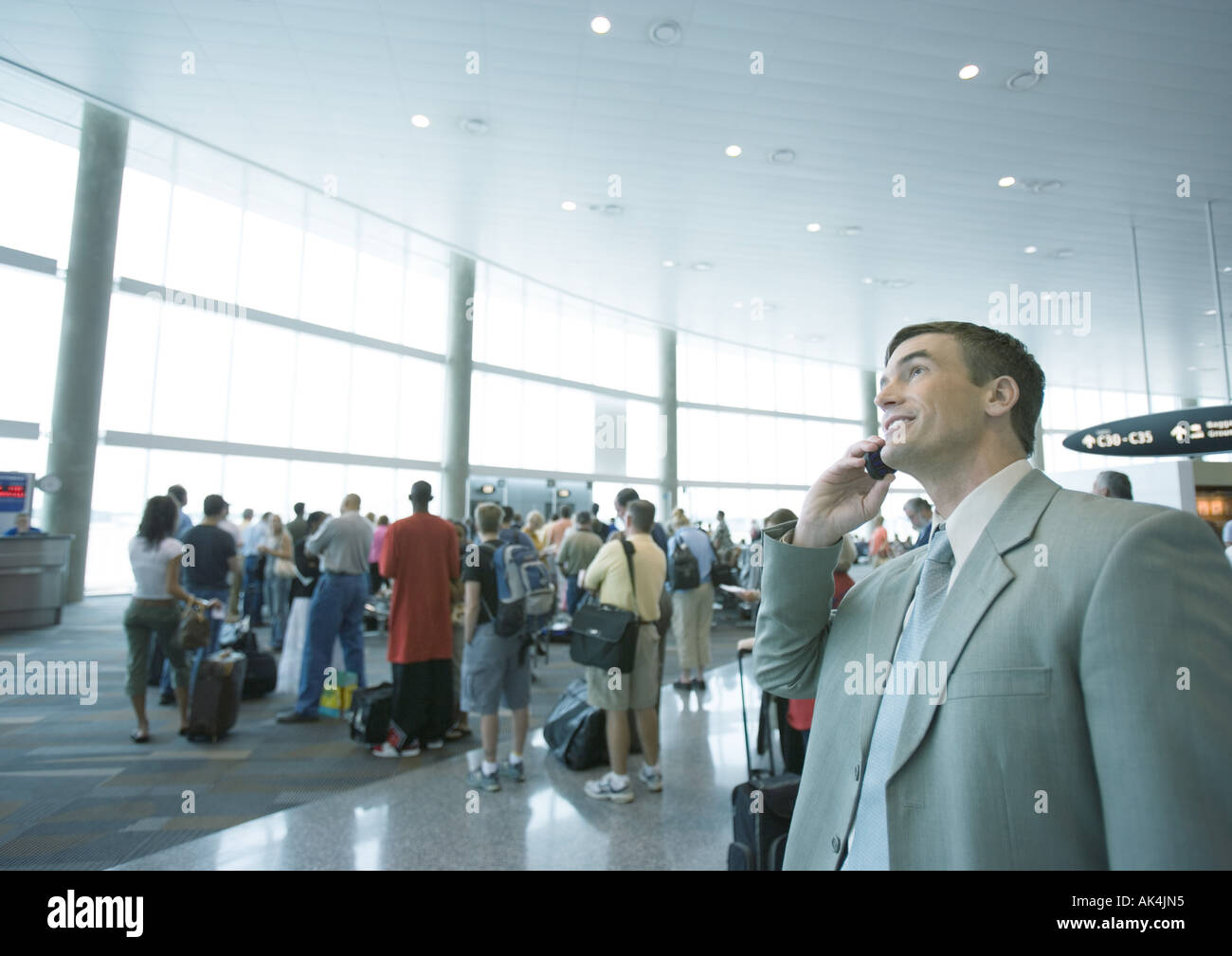 Businessman using phone in airport boarding area Stock Photo