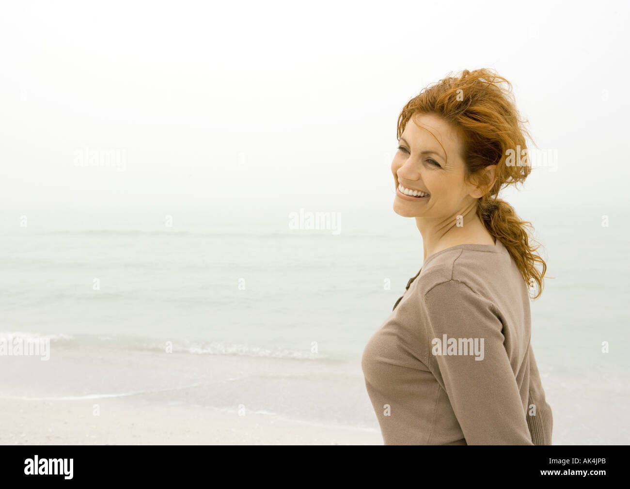Woman smiling on beach Stock Photo
