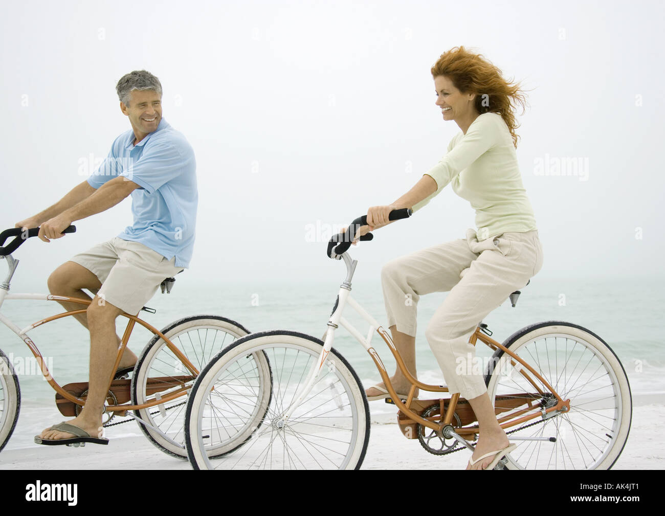 Couple Riding Bikes On Beach Couple Riding Bikes On Beach