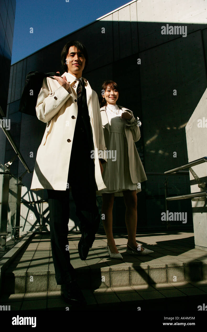 Businessman and woman walking down the stairs Stock Photo - Alamy