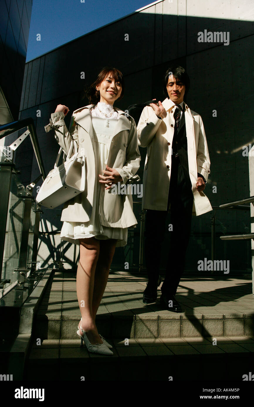 Businessman and woman walking down the stairs Stock Photo - Alamy